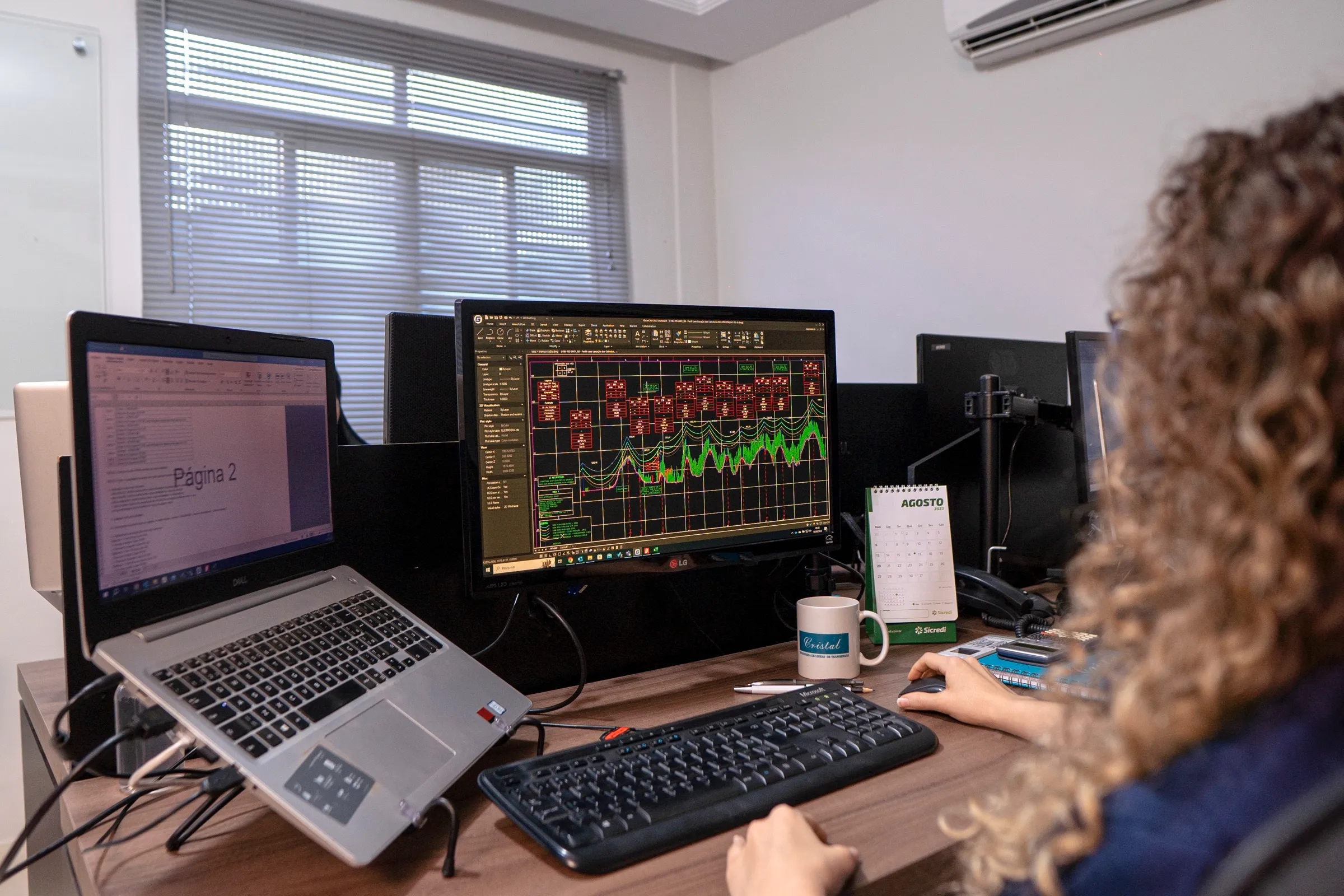 Engenheira da Cristal analisando o perfil de uma linha de transmissão no computador
